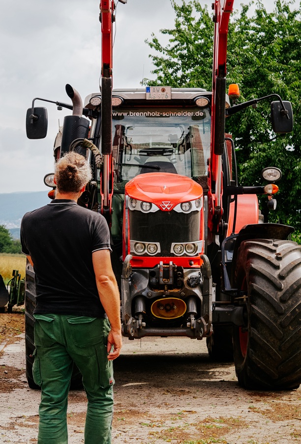 Alexander Schneider vor einem roten Traktor